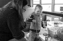 OUTSIDE THE BOX: Amanda Zaikow and her son Reed Worthen play with alphabet boxes on board the ORCA bus. (Photo by Bonnie Krakalovich)